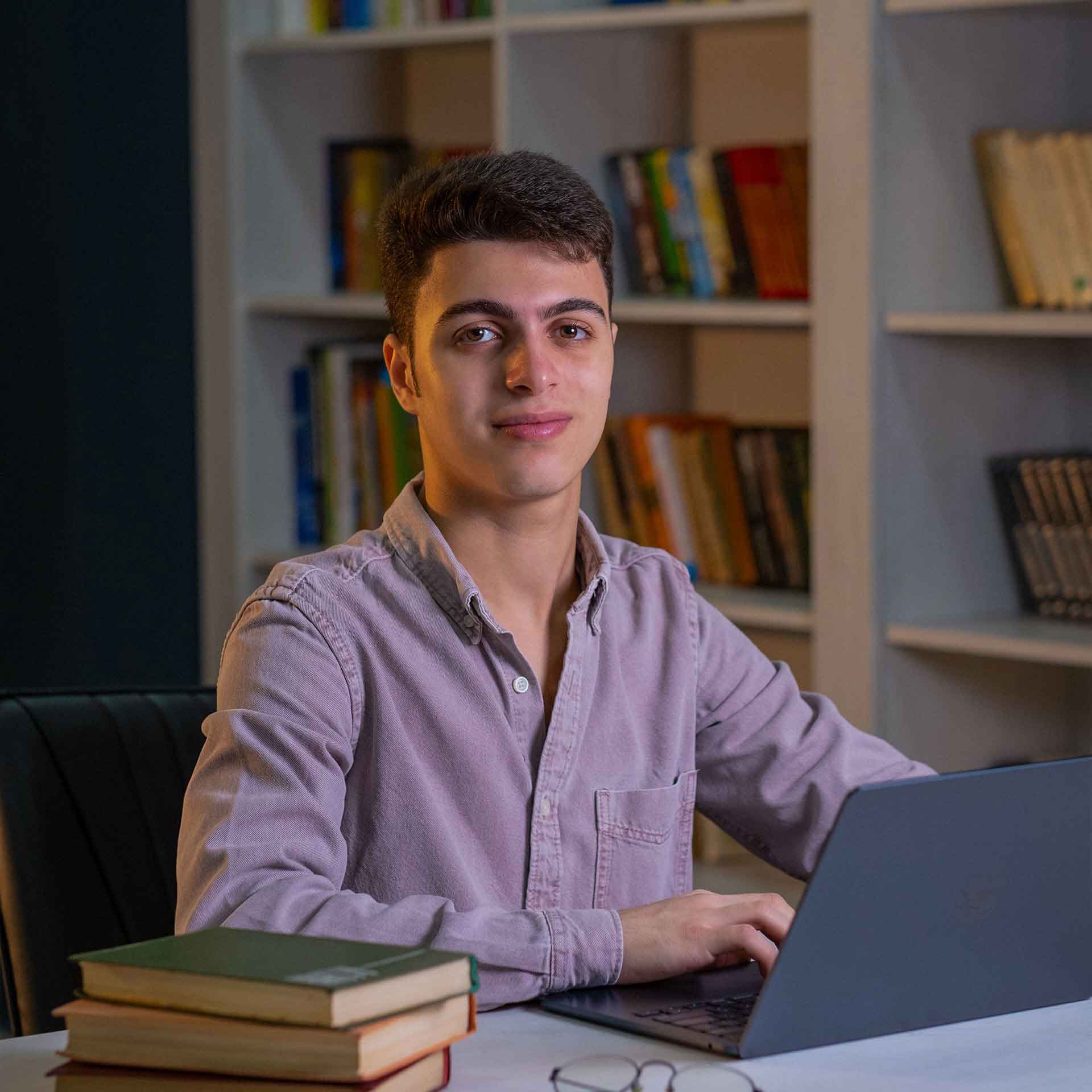 Soltan sitting with laptop and smiling